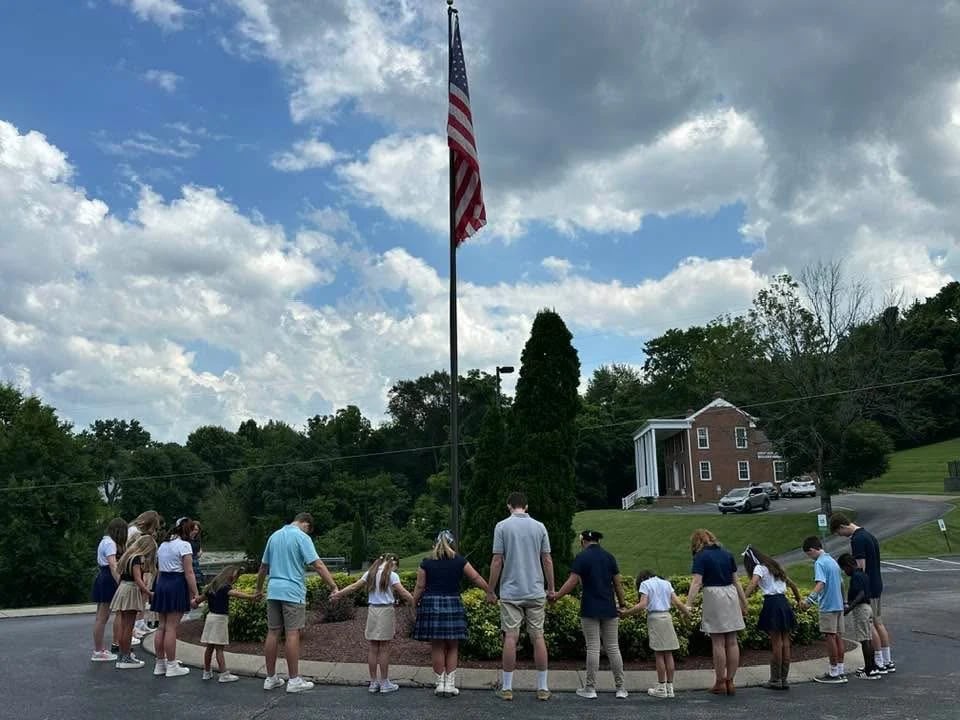 Safe Harbor students gathered around the flagpole